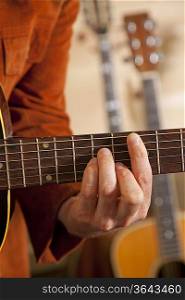 Close-up of mid adult man&acute;s fingers while playing guitar