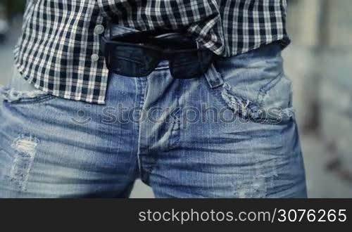 Close up of middle section of man with sunglasses over the belt making sexy movements while dancing
