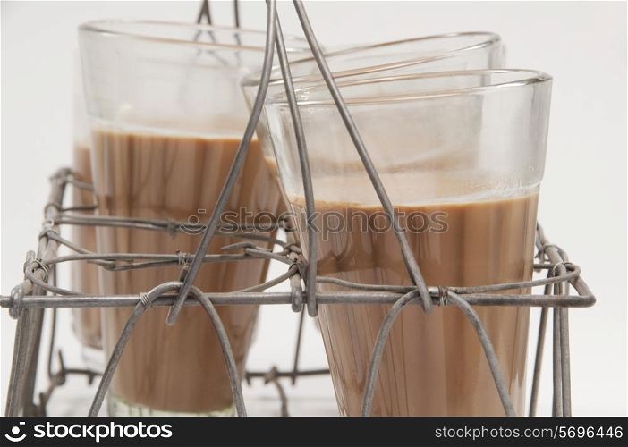 Close-up of milk tea kept in a metal grid tray isolated over white background