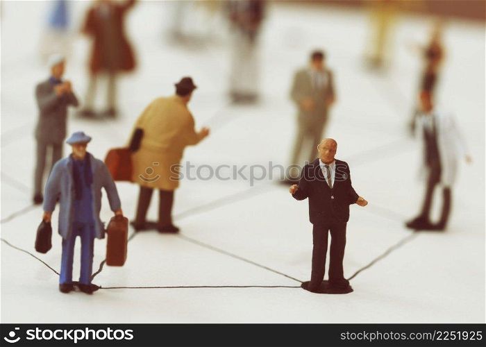 close up of miniature people with social network diagram on open notebook on wooden desk as social media conept