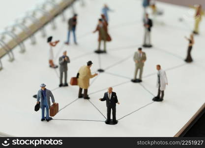 close up of miniature people with social network diagram on open notebook on wooden desk as social media conept