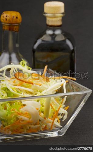 Close up of mixed salad with vinegar and oil on the background