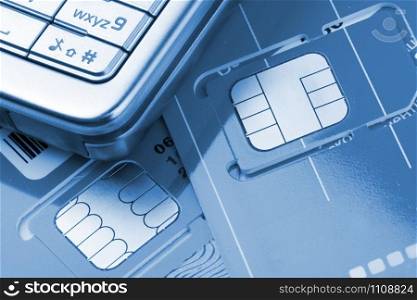 Close-up of mobile phone with sim cards. Toned in blue