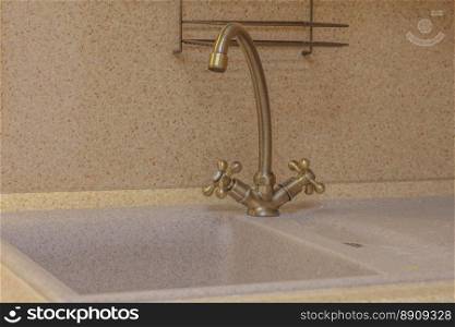Close up of modern faucet and ceramic sink in kitchen. Faucet in kitchen