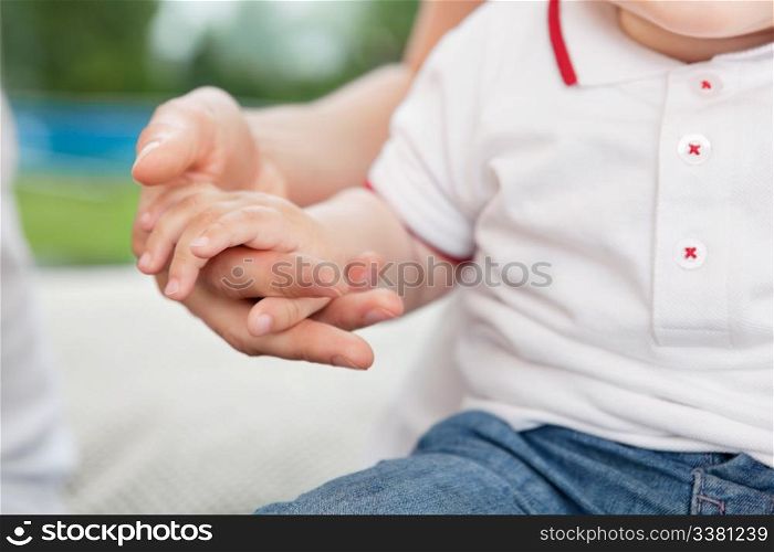 Close-up of mother holding child&rsquo;s hand
