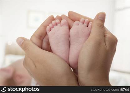 Close-up of mother holding her baby's feet