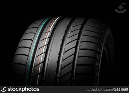 close up of new sport summer tire, over black, studio shot