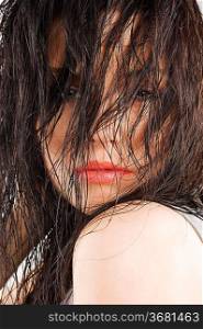 close-up of nice brunette keeping wet hair in front of her face and looking sensual in camera
