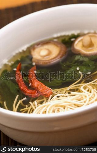 Close-up of noodles with red chili peppers in a bowl