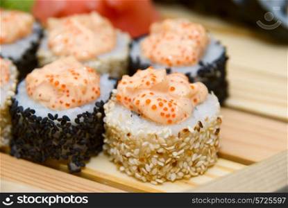 Close-up of of sushi on wood plate.