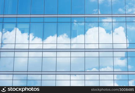 Close up of office building with reflection of blue sky and cloud. Business background.