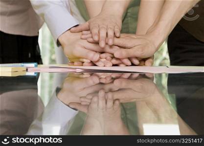Close-up of office workers stacking hands on a table