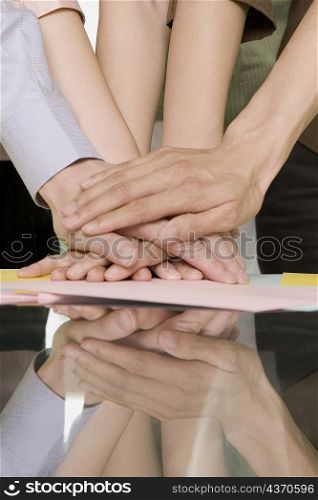 Close-up of office workers stacking hands on a table