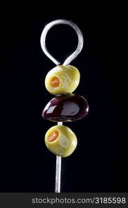 Close-up of olives on a metal skewer