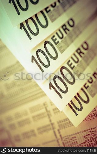 Close-up of one hundred euro banknotes with a financial newspaper