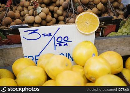 Close-up of oranges and plums at a market stall