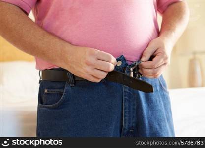 Close Up Of Overweight Man Trying To Fasten Trousers