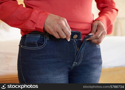 Close Up Of Overweight Woman Trying To Fasten Trousers