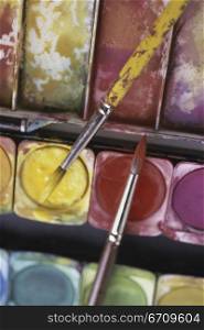 Close-up of paintbrushes on watercolors
