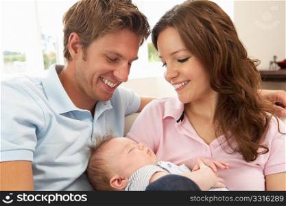 Close Up Of Parents Cuddling Newborn Baby Boy At Home