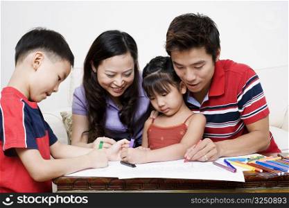 Close-up of parents drawing on paper with their children