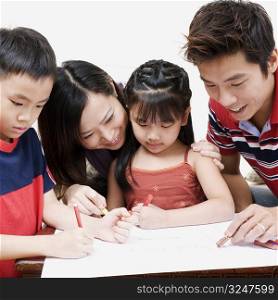 Close-up of parents teaching a boy and a girl how to color