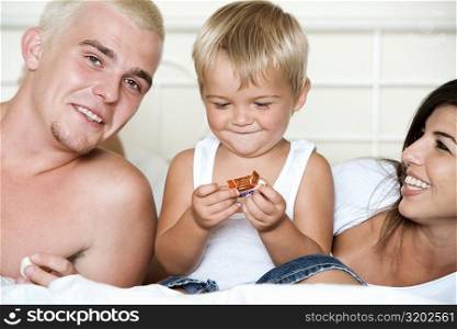 Close-up of parents with their son holding candy