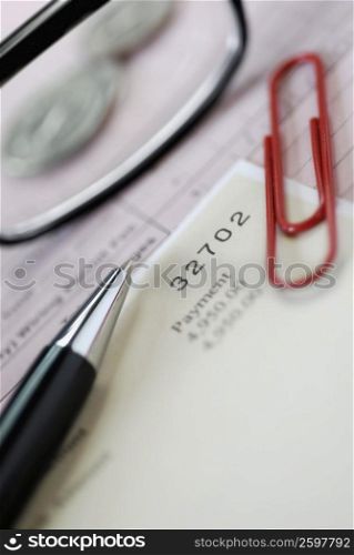 Close-up of pen and a paper clip on documents