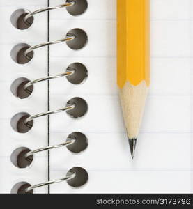 Close up of pencil on top of spiral bound notebook.