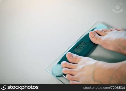 Close up of people feet standing on scale weighing.