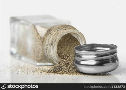 Close-up of pepper powder spilling out of a pepper shaker