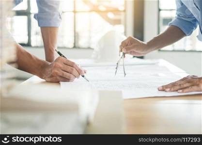 Close-up Of Person&rsquo;s engineer Hand Drawing Plan On Blue Print with architect equipment, Architects discussing at the table, team work and work flow construction concept.