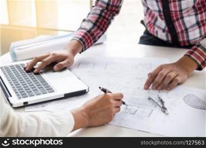 Close-up Of Person's engineer Hand Drawing Plan On Blue Print with architect equipment, Architects discussing at the table, team work and work flow construction concept.. Close-up Of Person's engineer Hand Drawing Plan On Blue Print wi