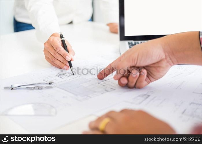 Close-up Of Person's engineer Hand Drawing Plan On Blue Print with architect equipment, Architects discussing at the table, team work and work flow construction concept.