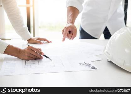 Close-up Of Person's engineer Hand Drawing Plan On Blue Print with architect equipment, Architects discussing at the table, team work and work flow construction concept.