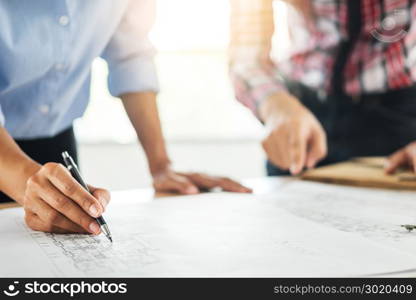 Close-up Of Person&rsquo;s engineer Hand Drawing Plan On Blue Print with architect equipment, Architects discussing at the table, team work and work flow construction concept.