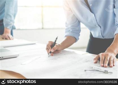 Close-up Of Person&rsquo;s engineer Hand Drawing Plan On Blue Print with architect equipment, Architects discussing at the table, team work and work flow construction concept.. Close-up Of Person&rsquo;s engineer Hand Drawing Plan On Blue Print wi