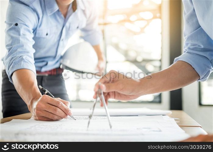 Close-up Of Person&rsquo;s engineer Hand Drawing Plan On Blue Print with architect equipment, Architects discussing at the table, team work and work flow construction concept.. Close-up Of Person&rsquo;s engineer Hand Drawing Plan On Blue Print wi