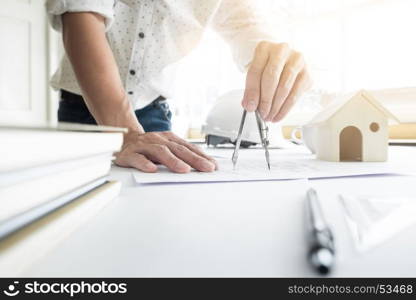 Close-up Of Person's engineer Hand Drawing Plan On Blue Print with architect equipment.