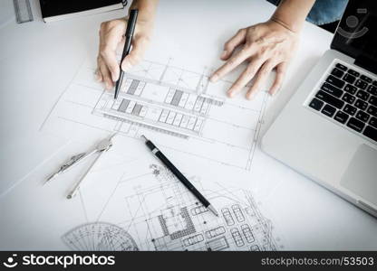 Close-up Of Person's engineer Hand Drawing Plan On Blue Print with architect equipment
