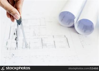 Close-up Of Person's Hand Drawing Plan On Blue Print with architect equipment