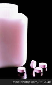 Close-up of pills with a pill bottle
