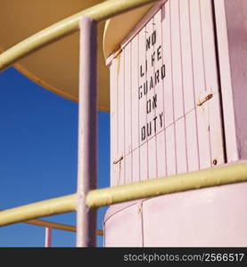 Close-up of pink art deco lifeguard tower with no lifeguard on duty sign in Miami, Florida, USA.