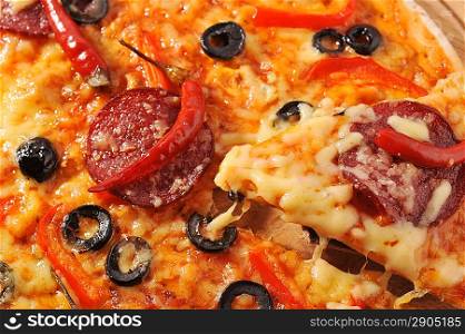 Close up of pizza with tomatoes, cheese, black olives and pepper