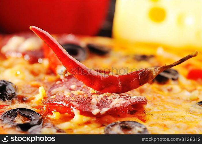 Close up of pizza with tomatoes, cheese, black olives and pepper