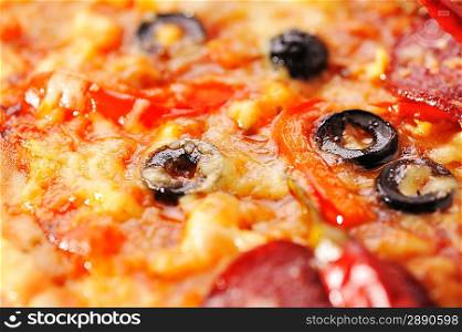Close up of pizza with tomatoes, cheese, black olives and peppers.