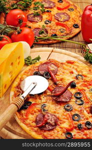 Close up of pizza with tomatoes, cheese, black olives and peppers.