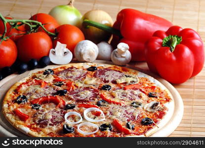 Close up of pizza with tomatoes, cheese, black olives and peppers.