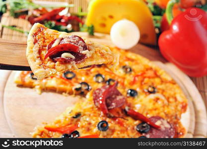 Close up of pizza with tomatoes, cheese, black olives and peppers.