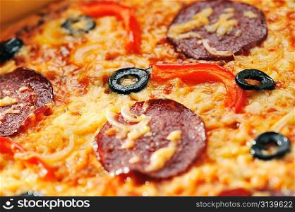 Close up of pizza with tomatoes, cheese, black olives and peppers